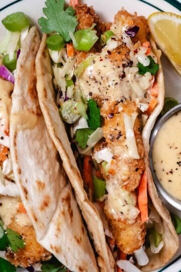 crispy tacos with taco sauce and lime wedges