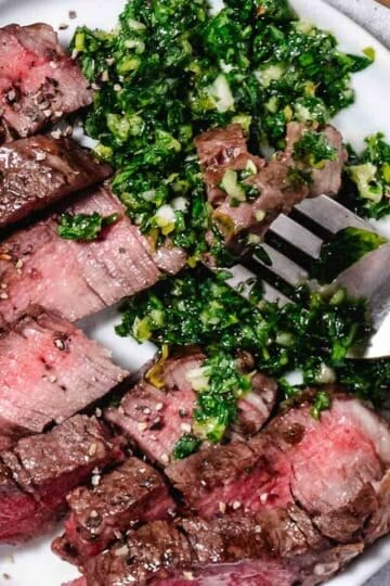 overhead view of porterhouse steak and gremolata sauce