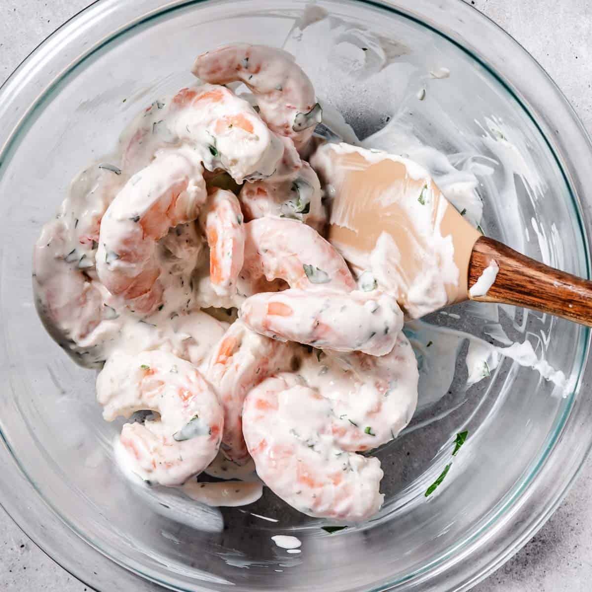 mixing shrimp with sour cream, cilantro, garlic, and salt
