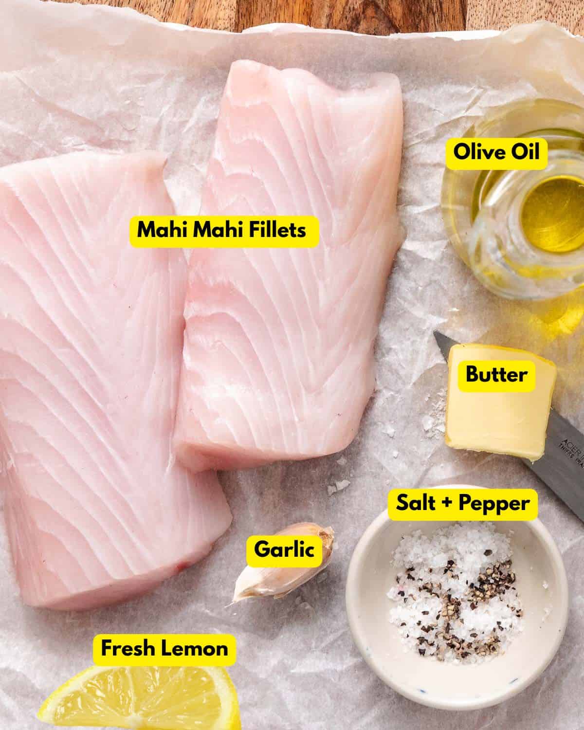 Pan-seared fresh mahi mahi fillet with garlic butter and parsley on parchment paper.