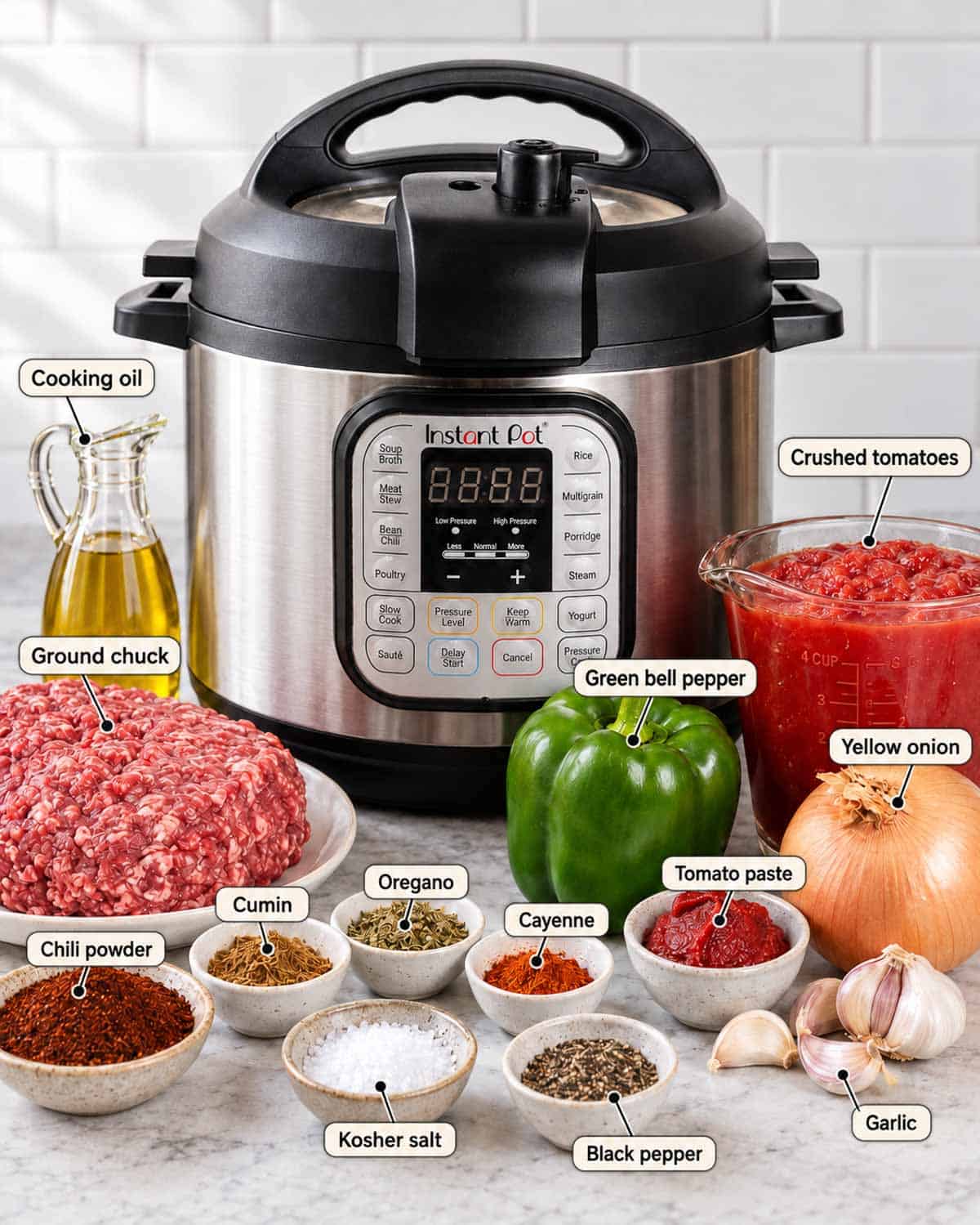 Ingredients for chuck steak chili, including ground chuck, tomatoes, bell pepper, onion, garlic, tomato paste, oil, and spices, arranged around an Instant Pot.