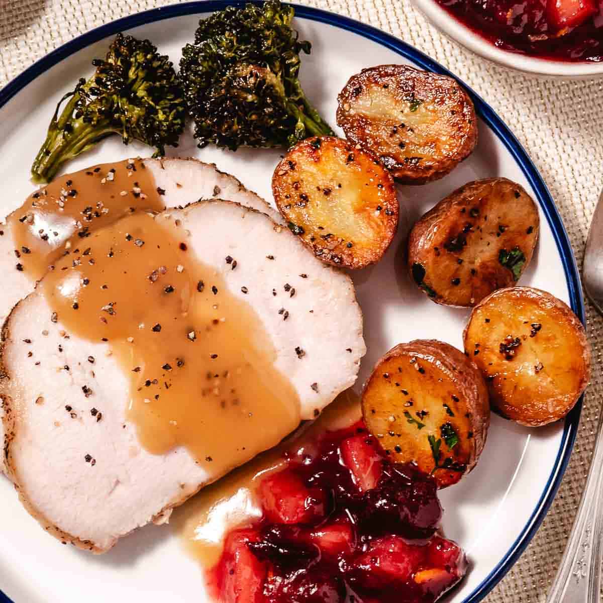 Juicy Butterball turkey breast roast served with cranberry sauce and roasted broccoli.