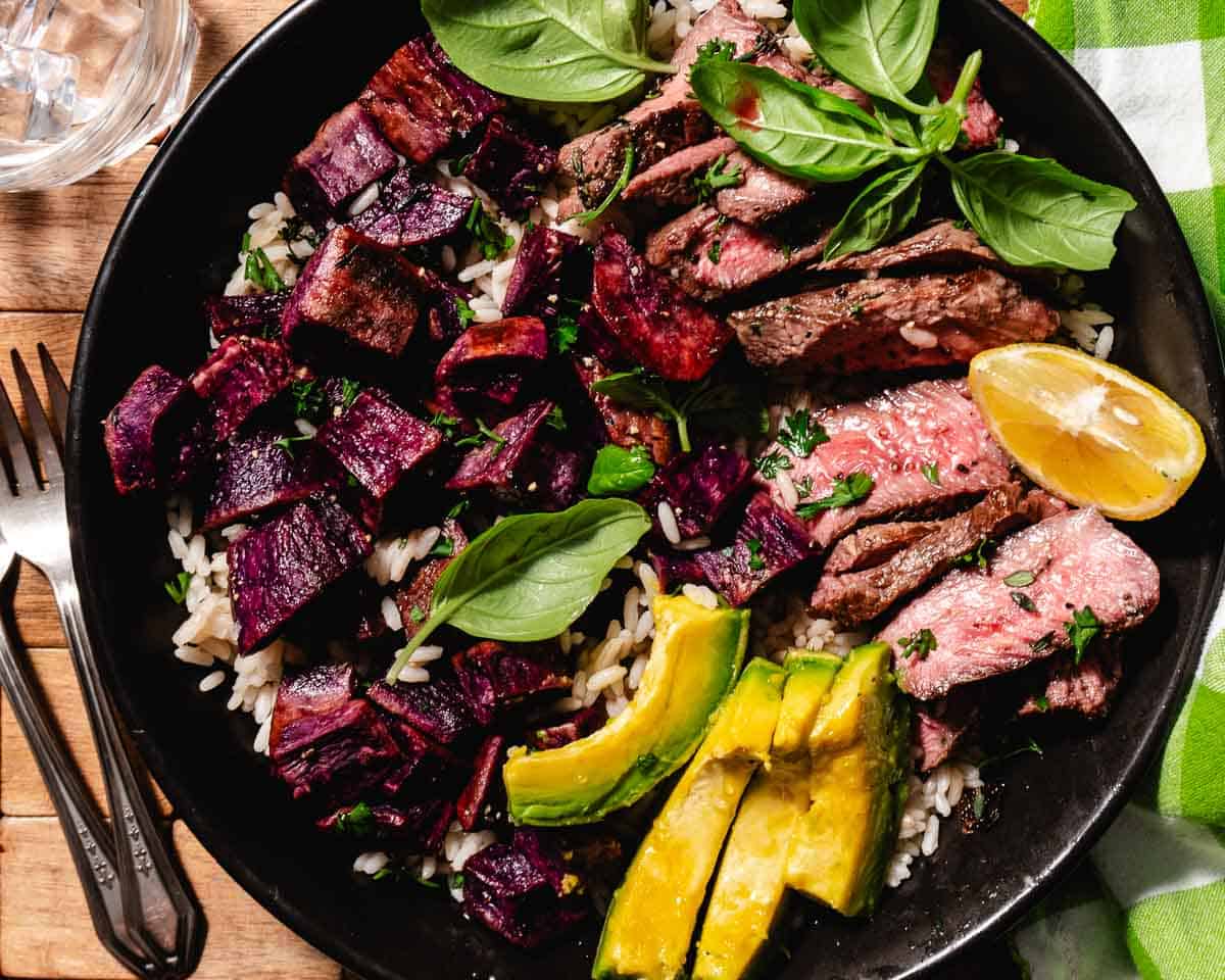 chuck tender medallions with purple sweet potatoes and sliced avocado