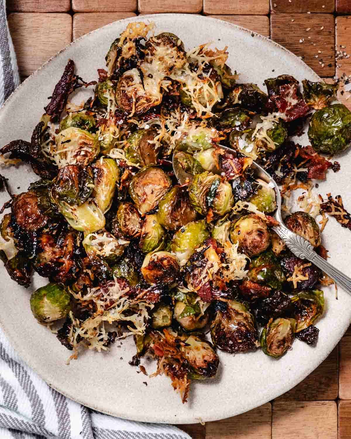 Brussels sprouts with bacon and cheese on a serving plate.