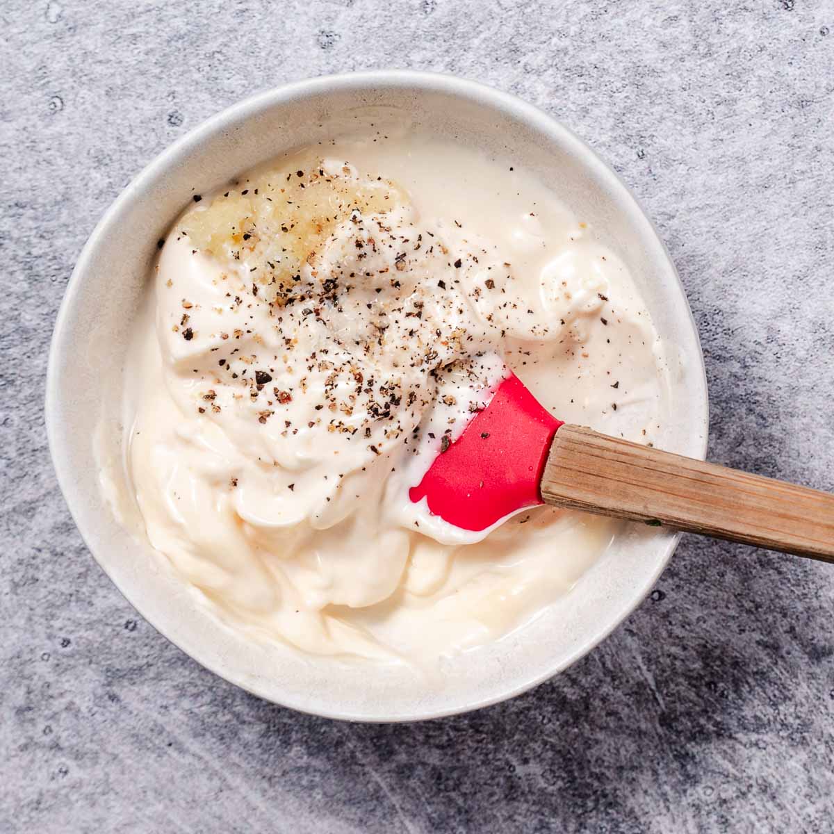 mixing garlic aioli in small bowl