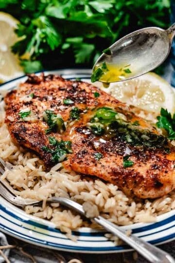 lemon butter sauce with garlic and herbs spooned over a peice of hogfish