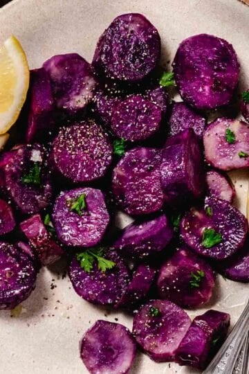 steamed purple sweet potatoes with salt, pepper, and lemon wedges