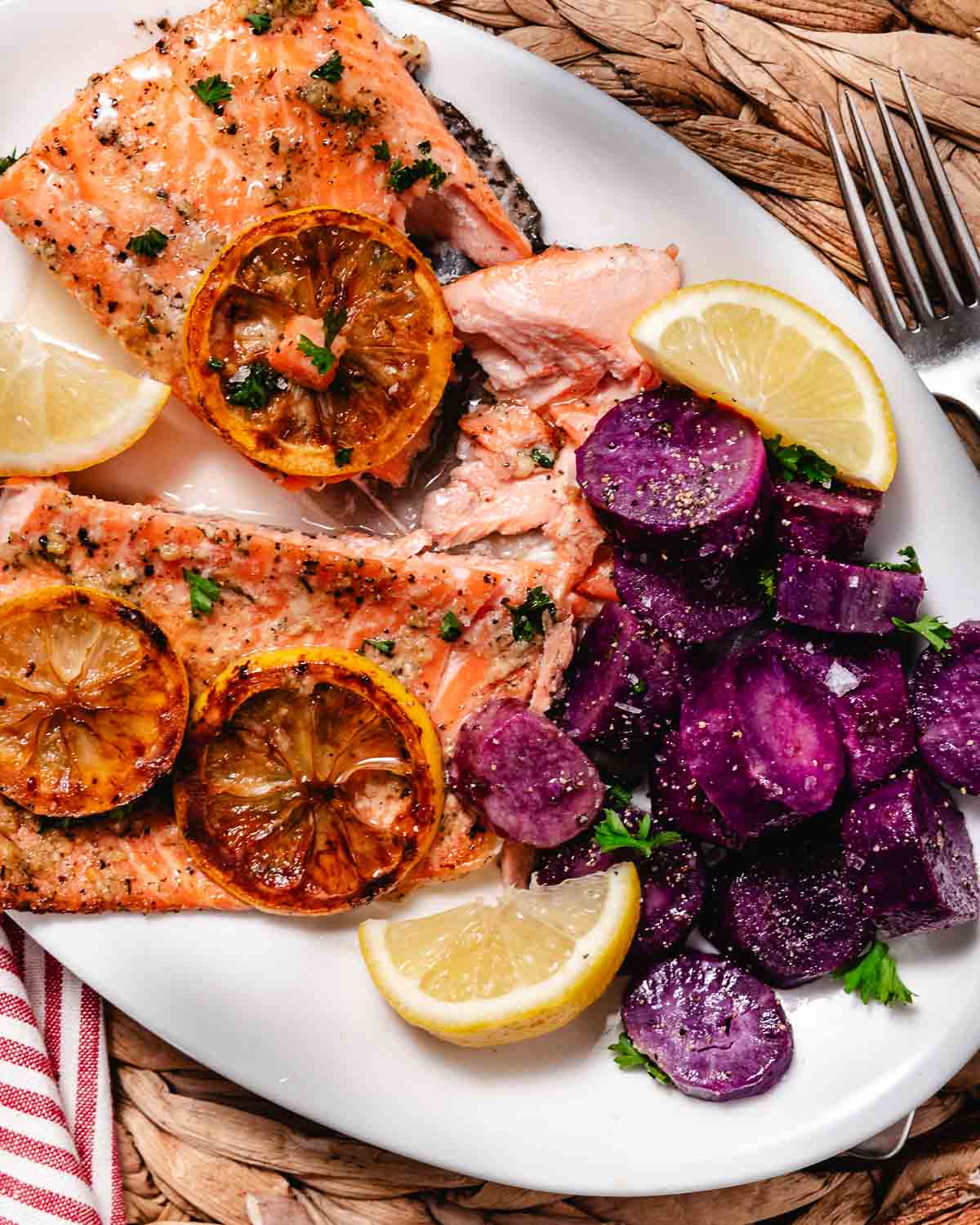 seared salmon with purple sweet potatoes and lemon wedges