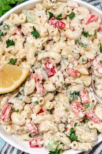 Elbow pasta mixed with tuna and vegetables in a white serving bowl.