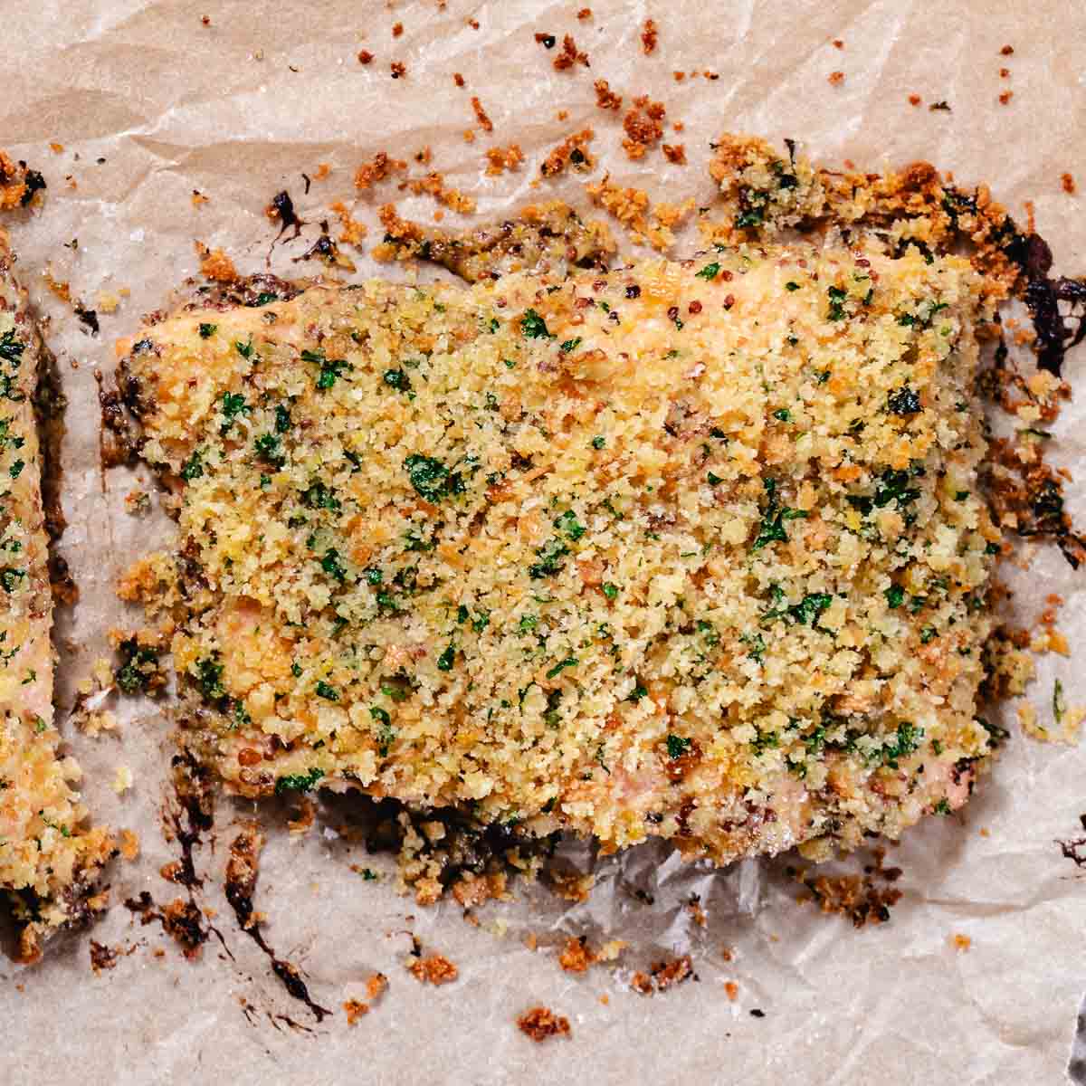 Baked Dijon salmon topped with toasted breadcrumbs on a baking sheet.
