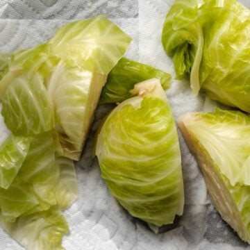 Cooked cabbage wedges resting on paper towels after boiling.