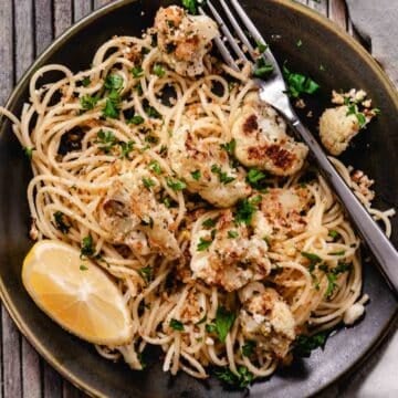 plate of roasted cauliflower with buttered crumbs and spaghetti