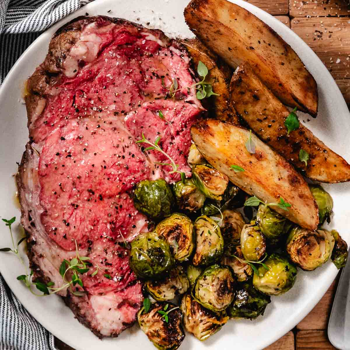 Small standing rib roast cooked to medium rare with Brussels sprouts and potatoes.
