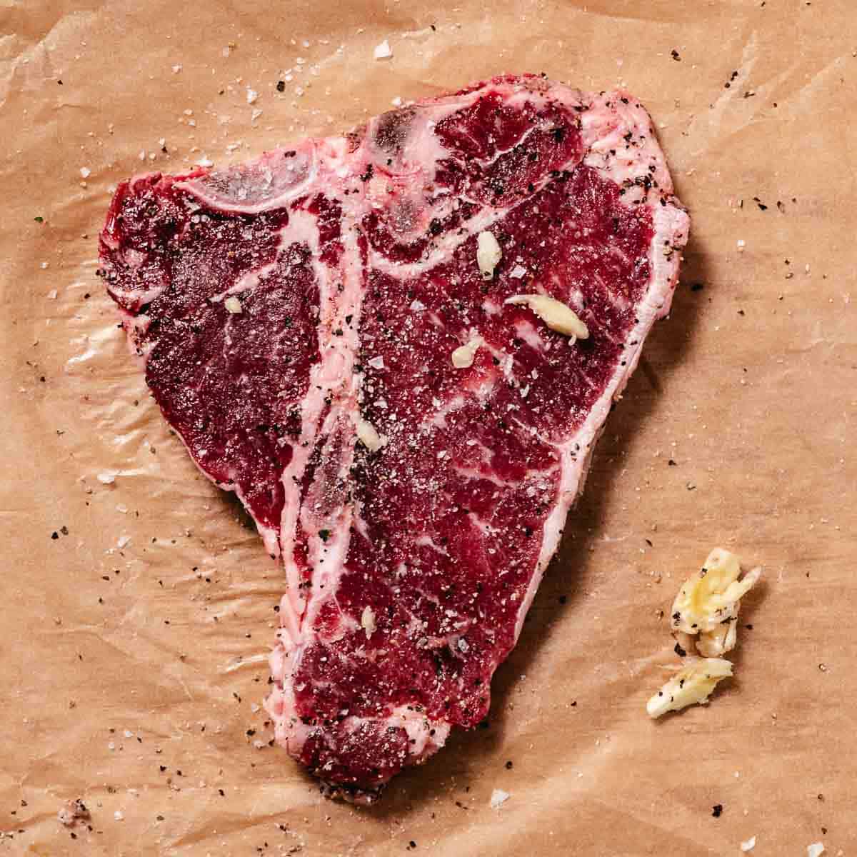 rubbing cut garlic all over a steak before cooking