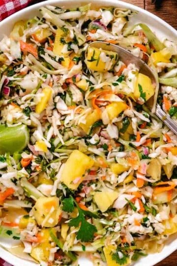 Close up of mango coleslaw with cabbage, carrots, cilantro, and lime dressing.