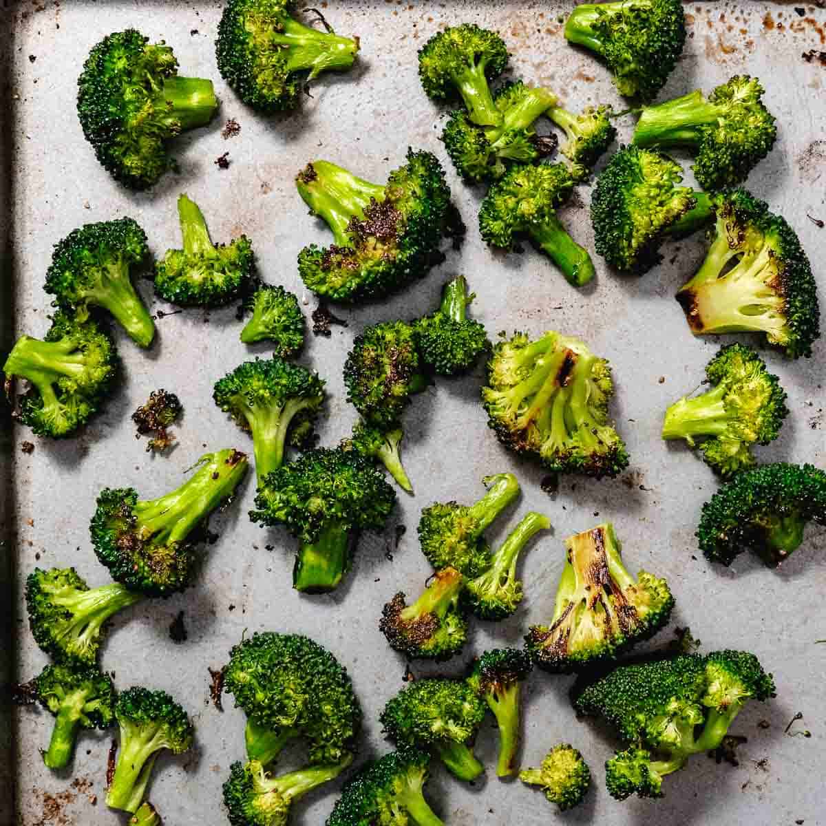 Roasted broccoli florets on a sheet pan with browned edges.
