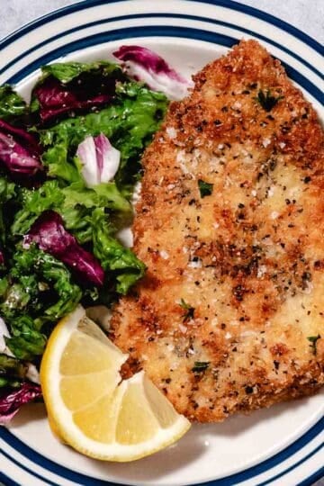 Crispy Panko Chicken Milanese topped with sea salt, served with a market-fresh salad of mixed greens and radicchio with a bright lemon wedge.