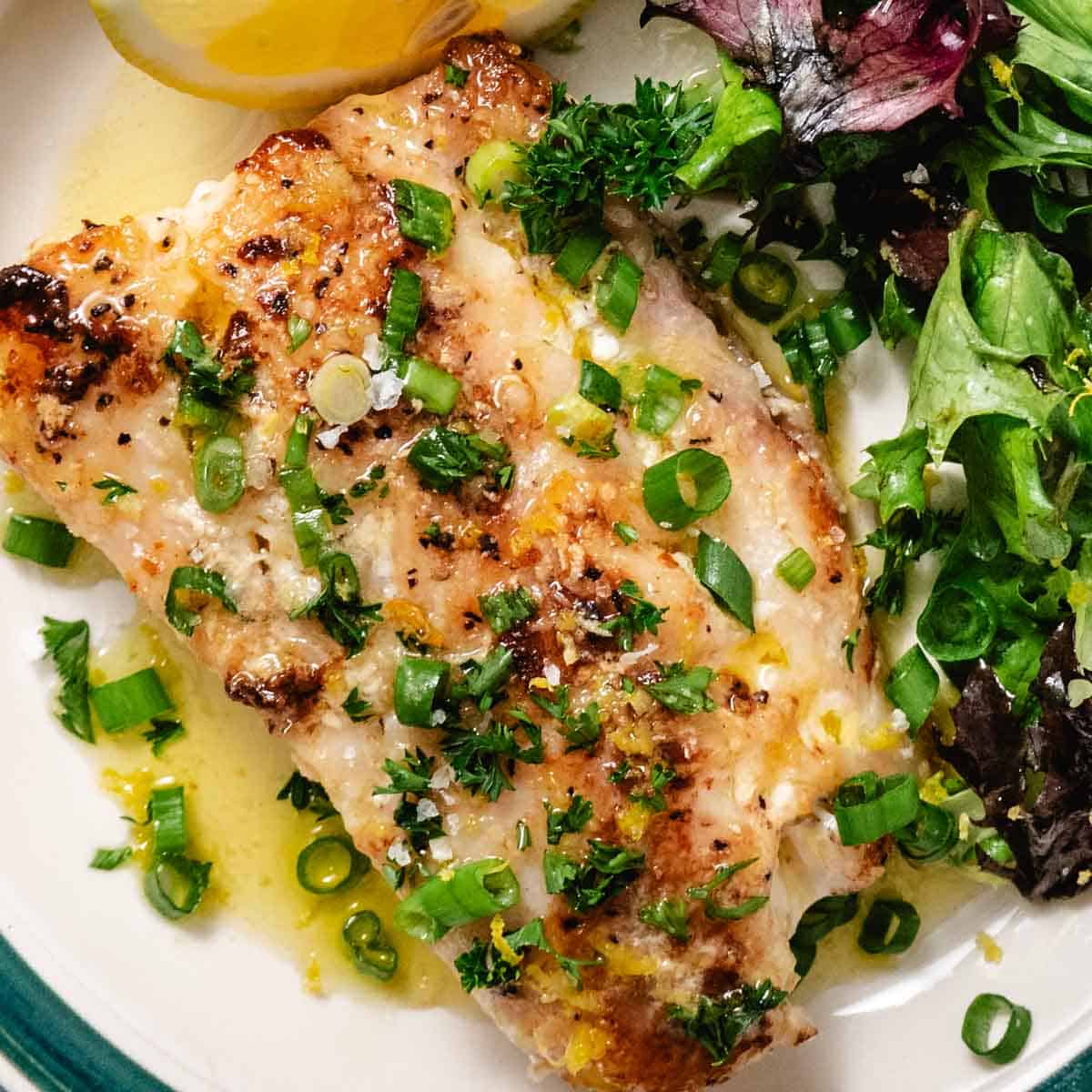 pan seared tilefish with a side salad and lemon wedge