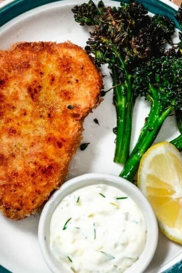 Fried swordfish with roasted broccolini and lemon on a plate