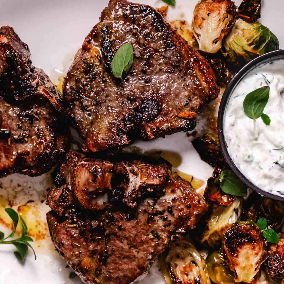 Air fryer lamb chops served with roasted Brussels sprouts and tzatziki sauce