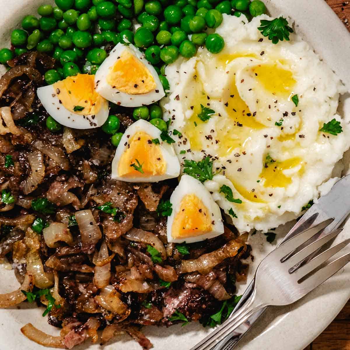 Baked beef liver and onions with mashed potatoes, peas, and boiled eggs
