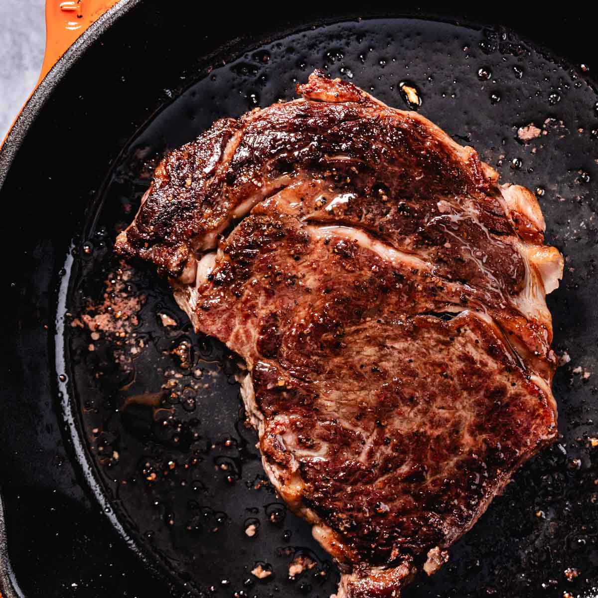 cooking rib eye in skillet
