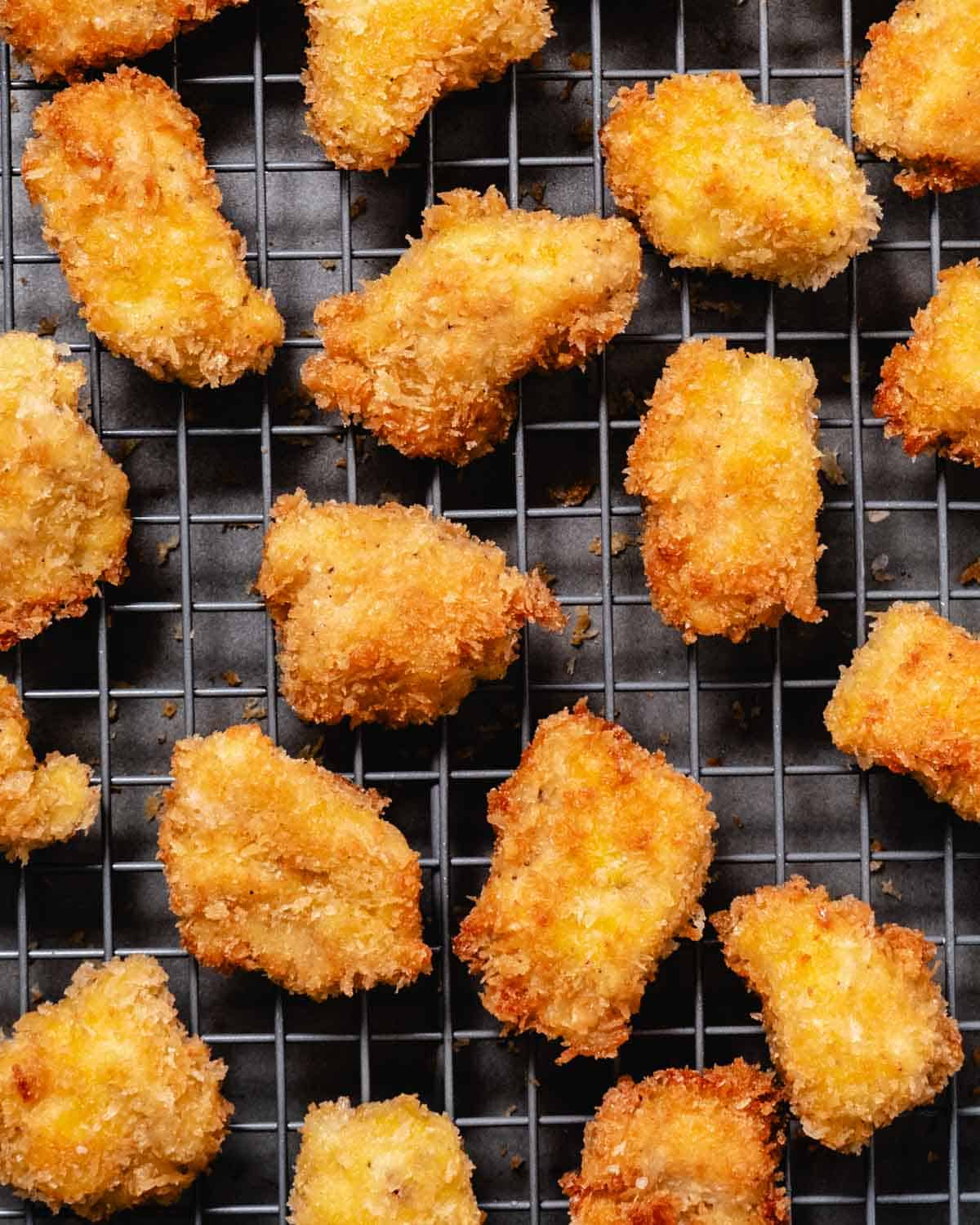 pan fried chicken nuggets cooling on wire rack
