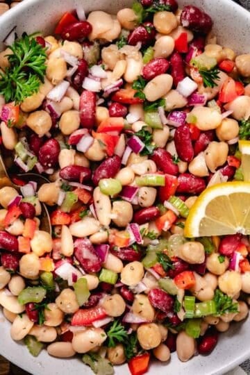 3 bean salad with chickpeas, kidney beans, white beans, celery, red onion, and herbs in a vinaigrette