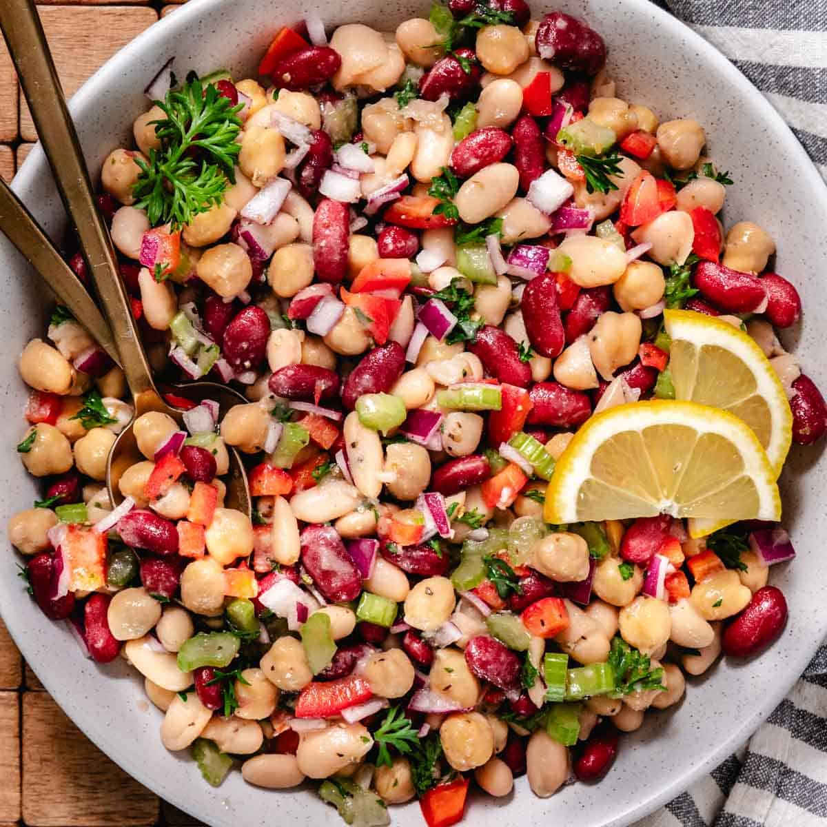 3 bean salad with chickpeas, kidney beans, white beans, celery, red onion, and herbs in a vinaigrette