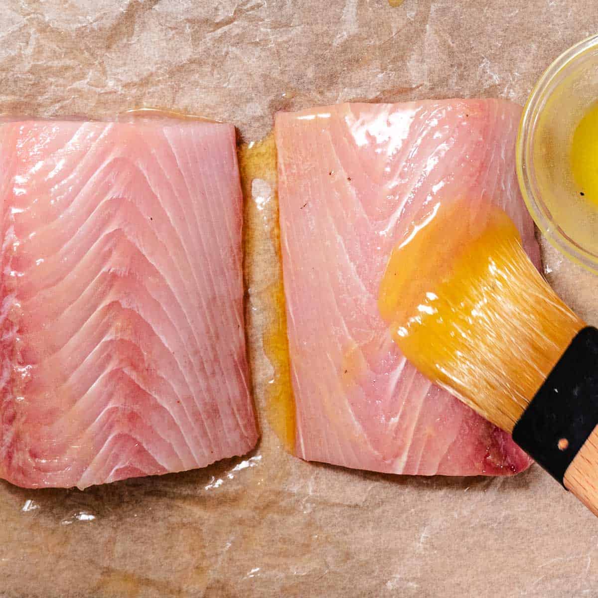 Brushing mahi mahi with melted butter before cooking