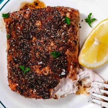 Flaky blackened mahi mahi with a fork showing the moist interior of the fish.