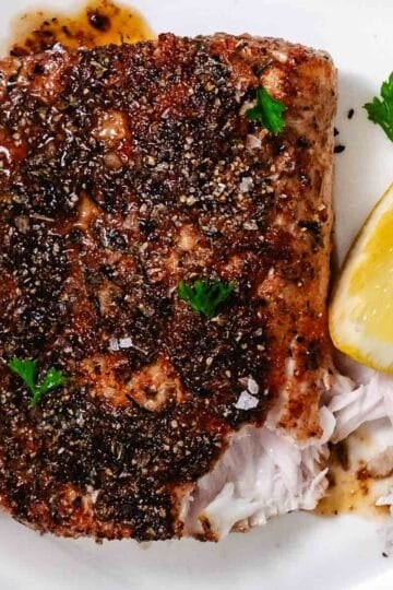 Flaky blackened mahi mahi with a fork showing the moist interior of the fish.