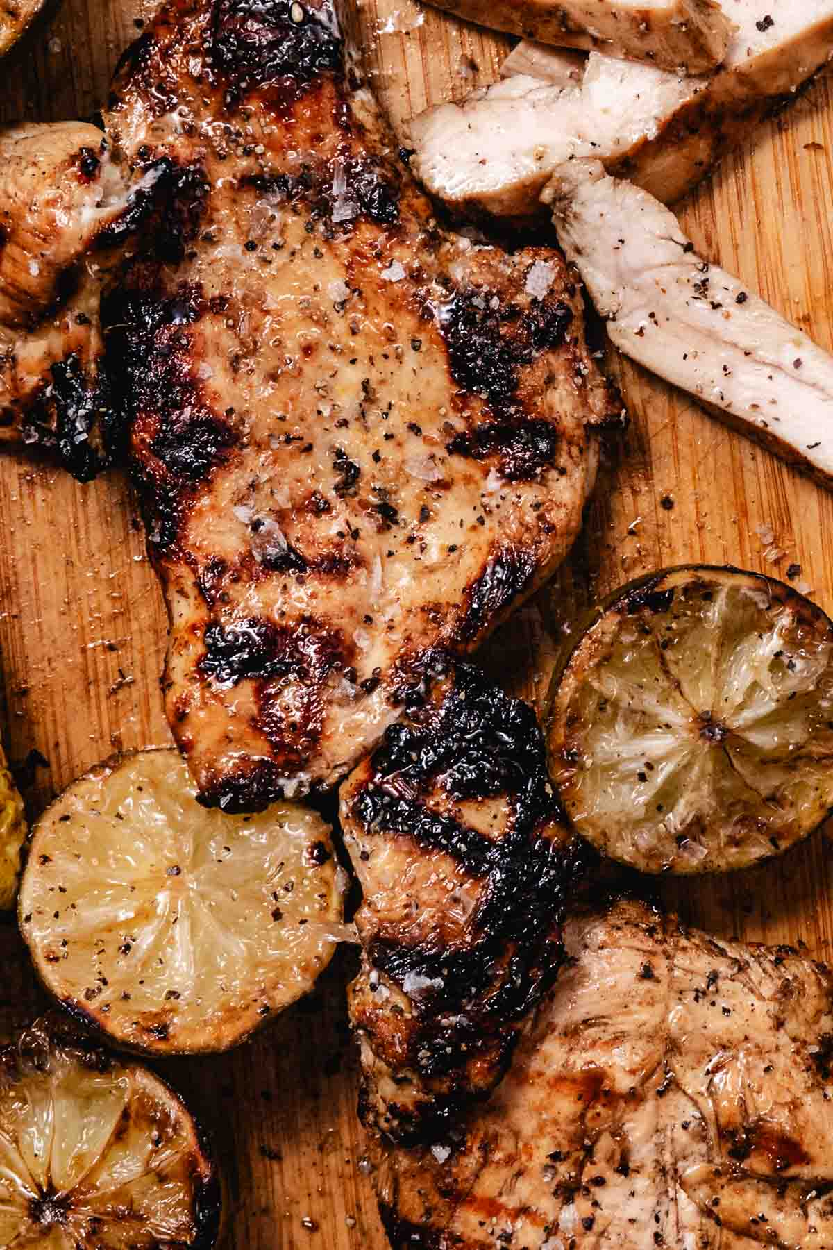 grilled mojo chicken with charred lime halves on a cutting board