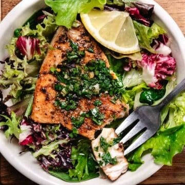 Pan-seared swordfish steaks over mixed green salad topped with chimichurri sauce.