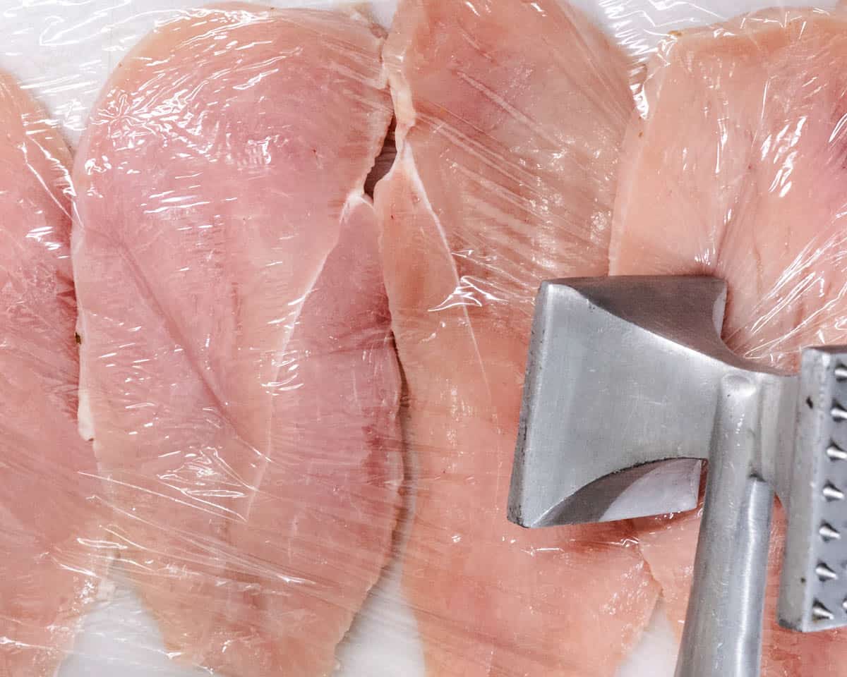 pounding chicken with a meat mallet to make thin cutlets