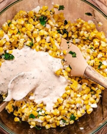 mixing dressing into street corn salad