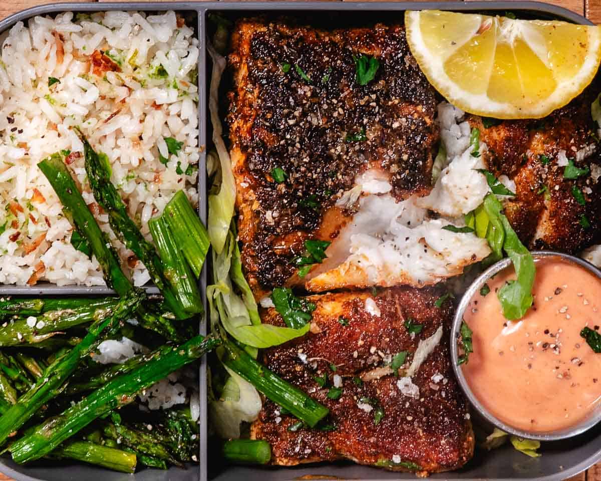 Cajun blackened grouper with coconut rice, roasted asparagus, lemon, and remoulade.