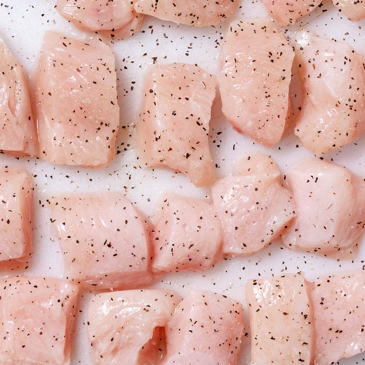 Diced chicken breast on a cutting board.