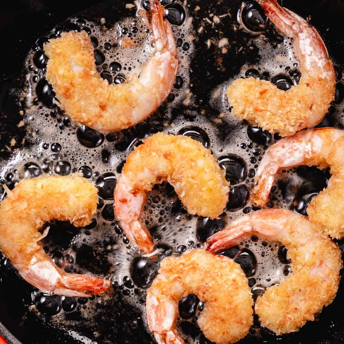 frying breaded shrimp in a skillet