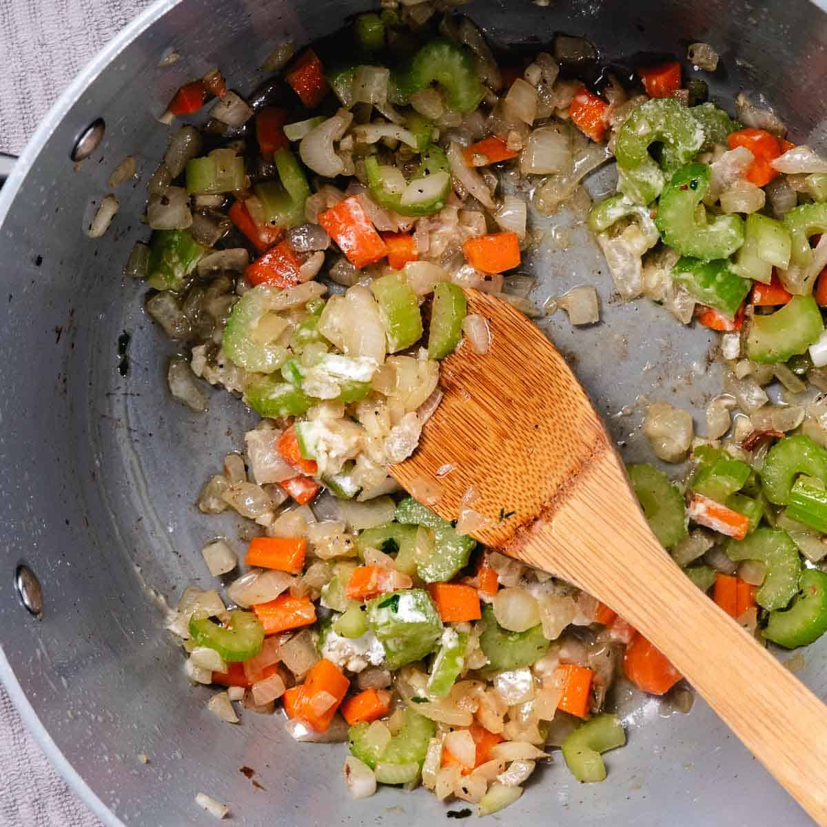Flour stirred into onion, celery, and carrots to make a roux for shrimp chowder.