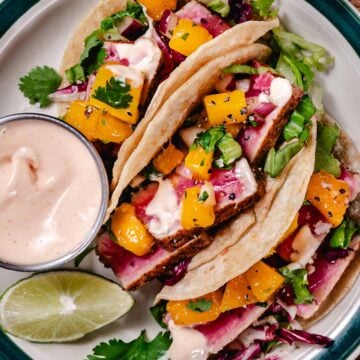 Blackened tuna tacos with mango salsa, lettuce, and spicy mayo on corn tortillas