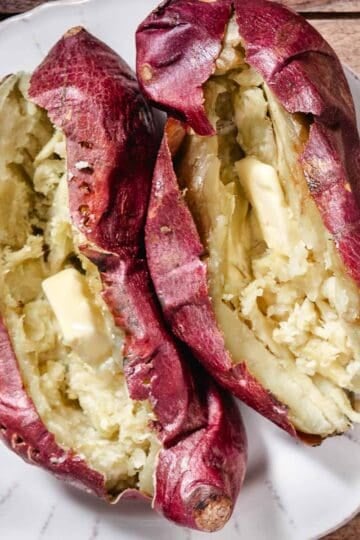 Baked Japanese sweet potatoes split open with melting butter
