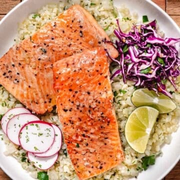 Pan seared coho salmon with garlic butter, cilantro lime cauliflower rice, red cabbage, and sliced radishes.