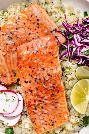 Pan seared coho salmon with garlic butter, cilantro lime cauliflower rice, red cabbage, and sliced radishes.