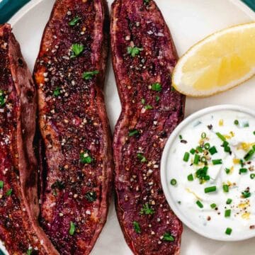 Roasted purple sweet potato halves with lemon chive sour cream dip