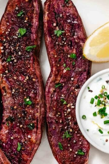 Roasted purple sweet potato halves with lemon chive sour cream dip