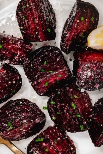 Roasted red beets with a lemon wedge.