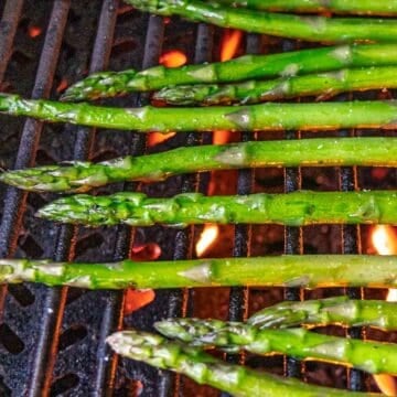 Grilling asparagus spears on gas grill.