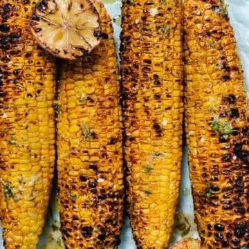 Grilled corn on the cob with Old Bay seasoning, charred limes, and garlic lime butter.