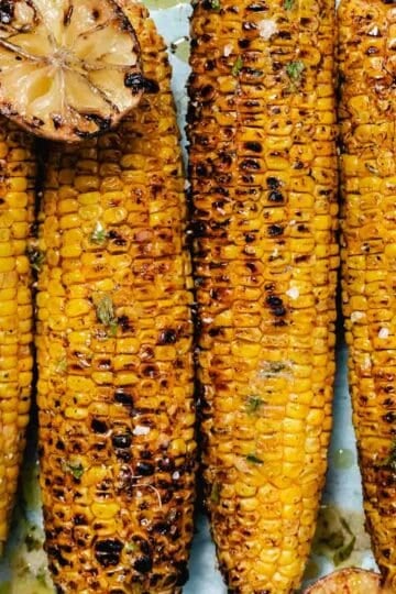 Grilled corn on the cob with Old Bay seasoning, charred limes, and garlic lime butter.